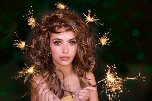 Fille avec des lumières du Bengale dans les cheveux