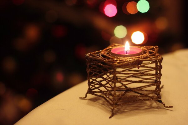 A small candle in a wicker candlestick