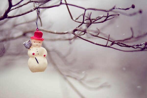Snowman on a tree in snowy winter