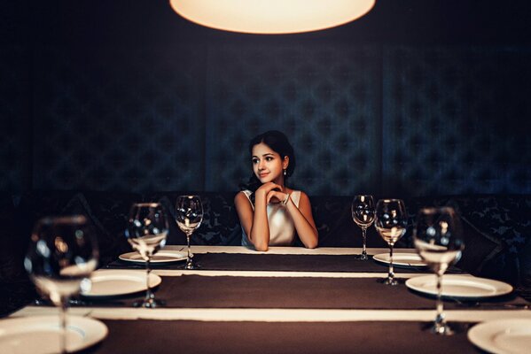 Brunette fille à la table avec des verres