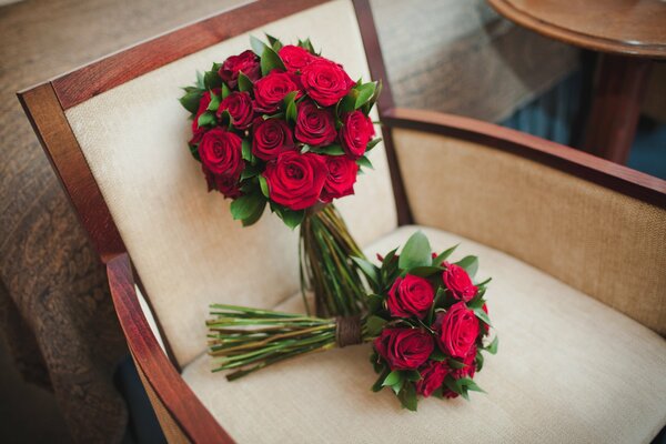 Zwei Blumensträuße roter Rosen im Sessel
