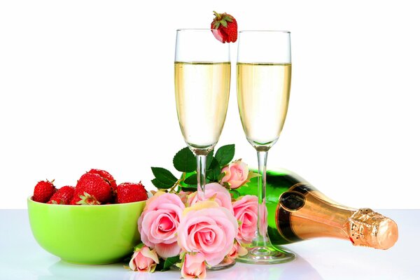 Bicchieri pieni di champagne, deliziose fragole e un profumato mazzo di rose