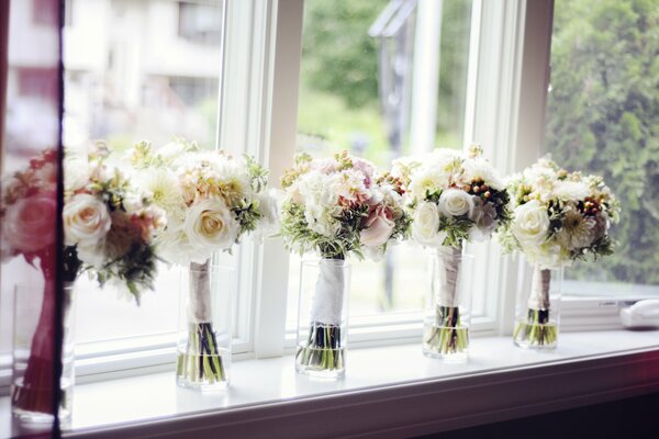 Bouquets délicats dans des vases sur le rebord de la fenêtre