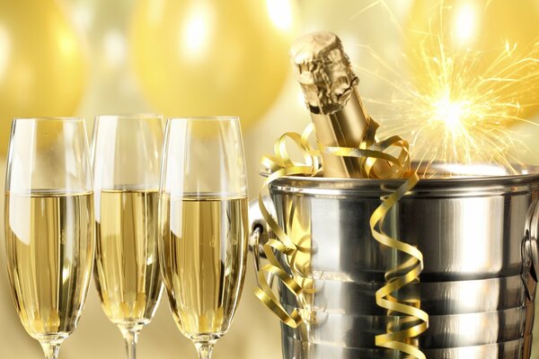 Bottiglia di champagne in un secchiello per il ghiaccio e bicchieri
