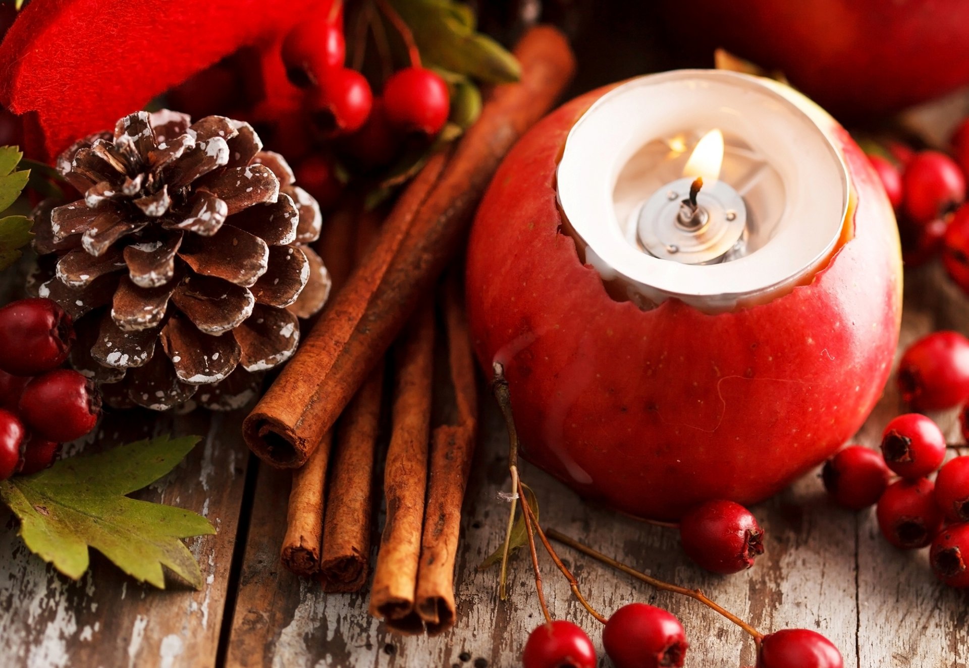 mela rosso candela pigna cannella bastoncini bacche foglie decorazioni vacanze natale capodanno