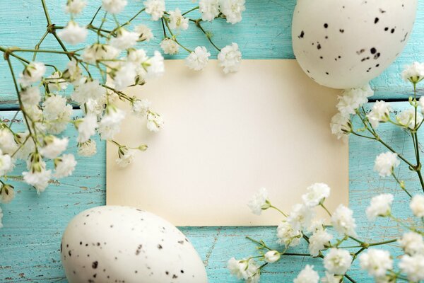 Oeufs de Pâques avec des fleurs séchées sur fond bleu