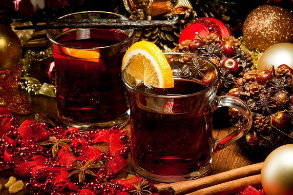 Weihnachtlicher Glühwein mit roten Bändern, Sternchen Anis, Zimtstangen und goldenen Kugeln