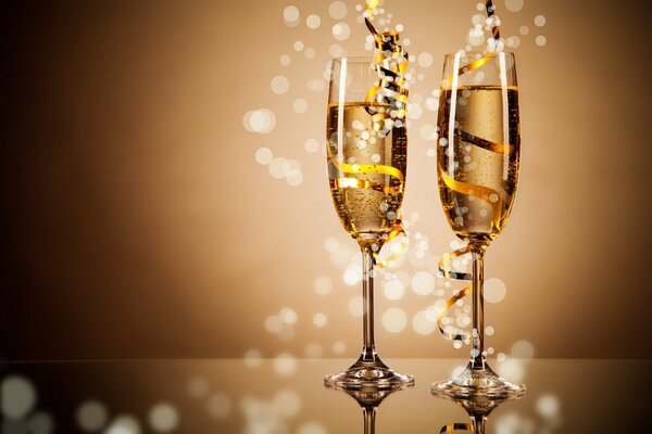 Two glasses of champagne for the new year with a gold ribbon and highlights