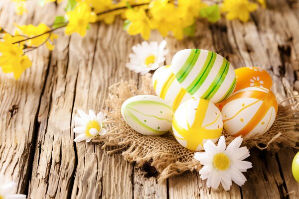 Huevos de Pascua con margaritas sobre un fondo de madera