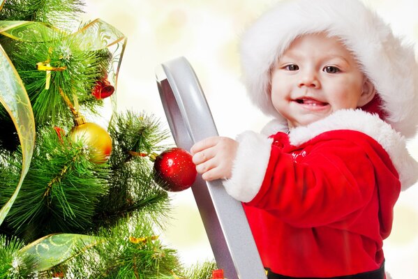 Niño pequeño en el árbol de Navidad