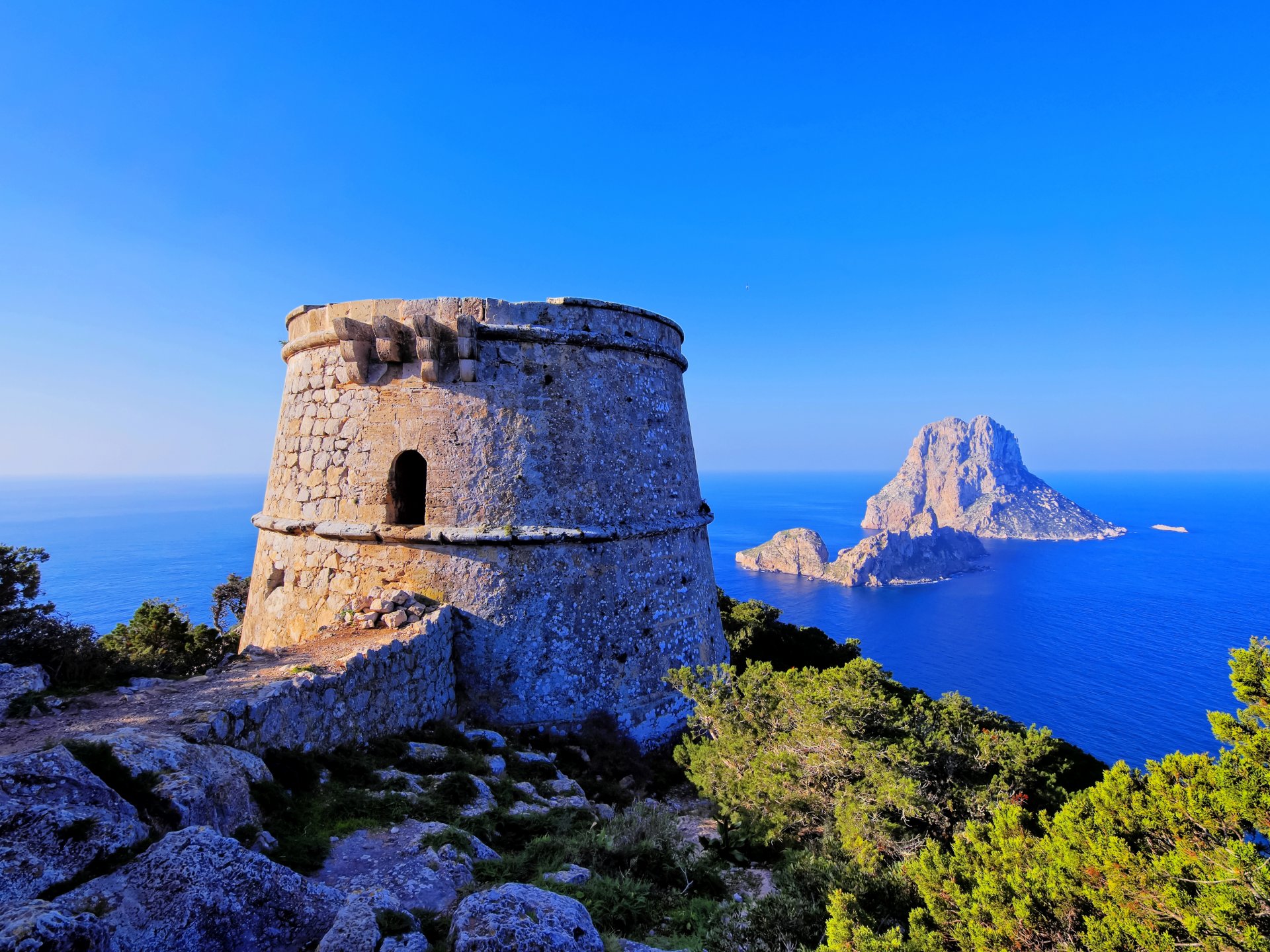 torre de savinar ibiza baleary hiszpania morze wyspy skała wieża twierdza kamienie krzewy horyzont niebo błękit