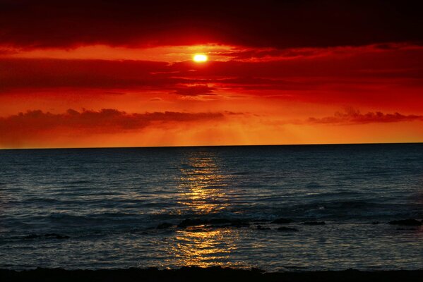 Puesta de sol carmesí en un mar tranquilo