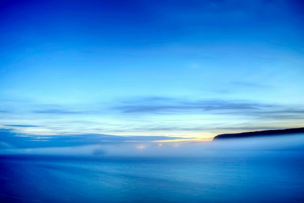 Niebla sobre la costa del mar y cielo en las nubes