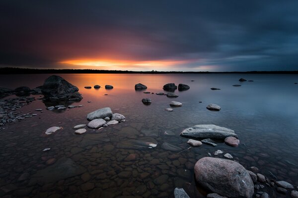 Amanecer en el mar, piedras costeras