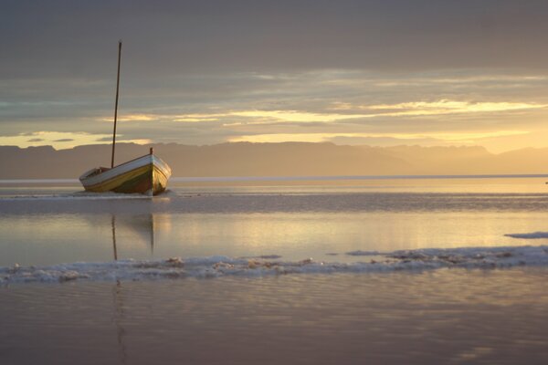The boat is stranded at sunset. On the sea