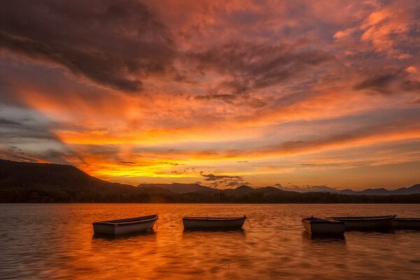 Wieczorny zachód słońca nad jeziorem z łodziami