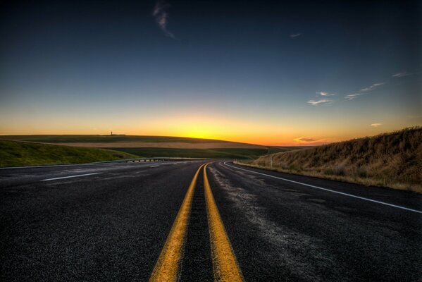 The road with markings going into the sunset