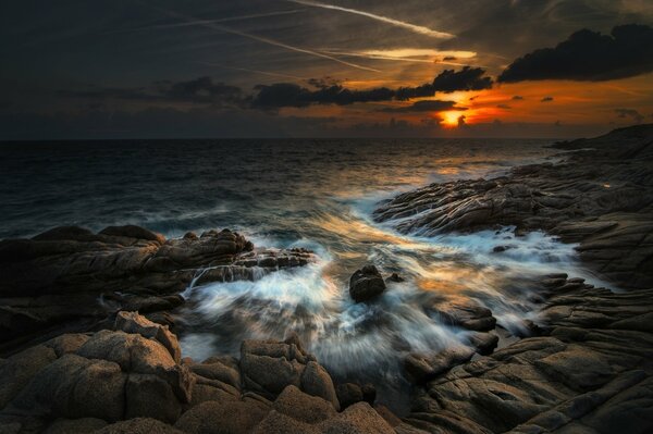 Olas que golpean la costa rocosa