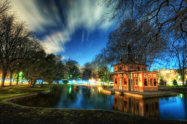 Maison dans le parc près de l étang avec de beaux nuages