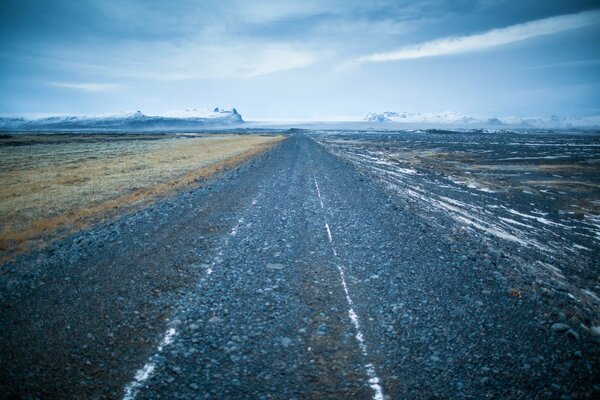 The road to the mountains through the field