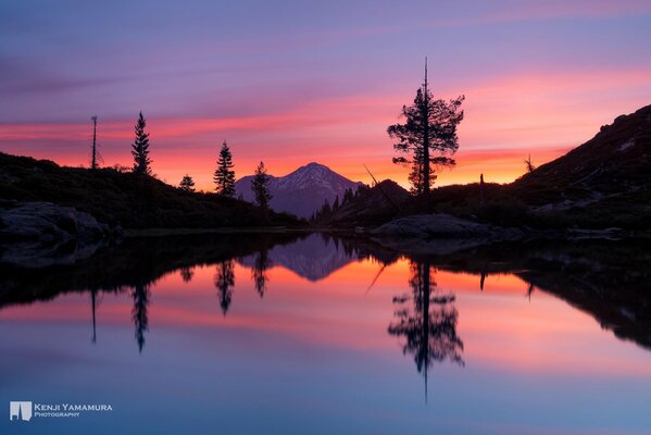 Tramonto luminoso su un tranquillo lago di montagna