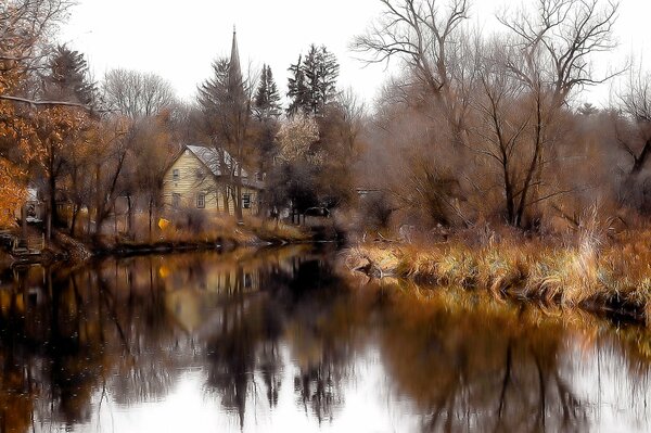 Dwupiętrowy domek nad jeziorem w lesie jesienią