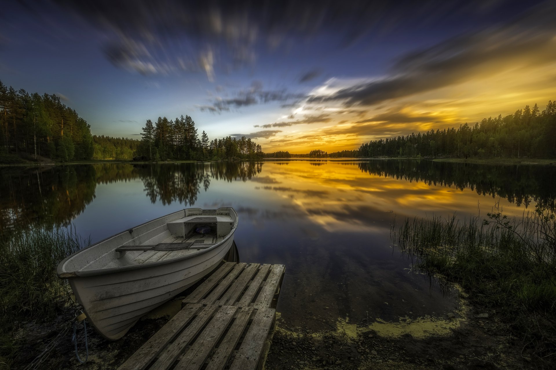 aklangen ringerike noruega lago puesta de sol barco árboles reflexión