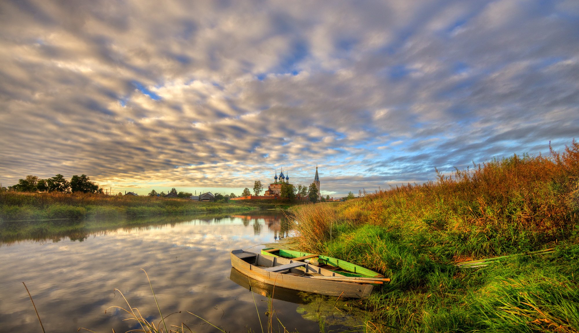 dorf kirche fluss ufer gras boote abend sonnenuntergang herbst