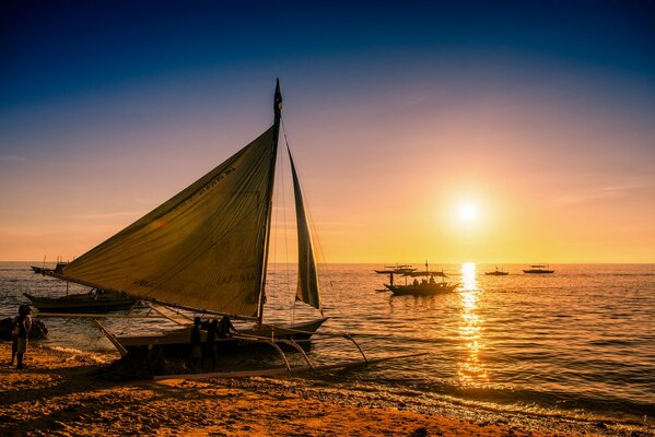Boat at the shore at sunset. Calm evening sunset over the sea in the Philippines