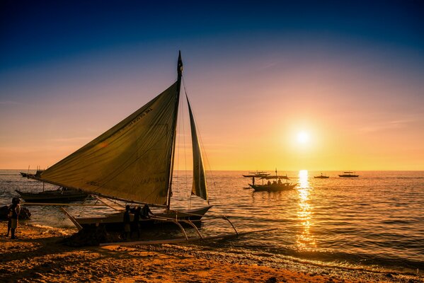 Barco en la costa al atardecer. Una tranquila puesta de sol sobre el mar en Filipinas