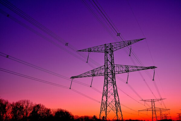 Torri che collegano i fili al tramonto serale