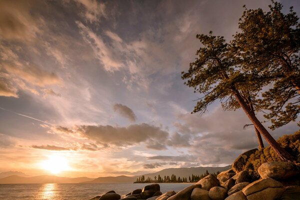 Rocheux avec des arbres bord du lac au coucher du soleil