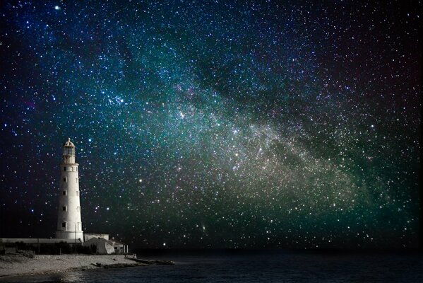 Costa. Faro. Cielo estrellado