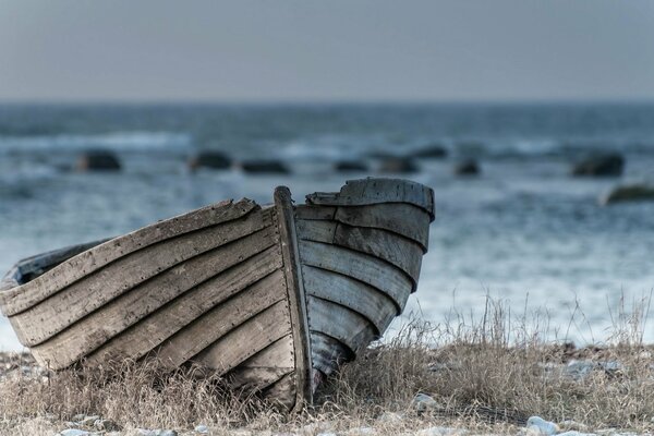 Old wooden boat on the background of the sea