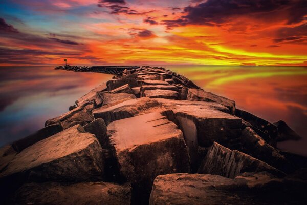 Un Alba rossa brillante dovrebbe essere il mare tra cui si estende un frangiflutti