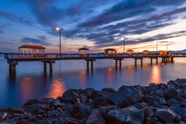 Langer Pier mit Häusern vor dem Hintergrund des Nachthimmels