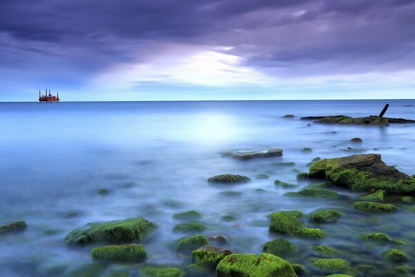 Mer bleue brumeuse parmi les pierres