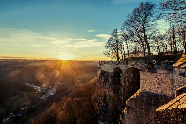 Fortress against the background of sunset and bare trees