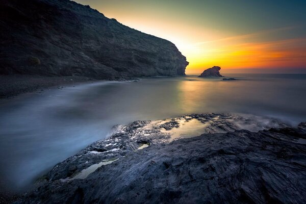 Sonnenuntergang über Meer und Felsen