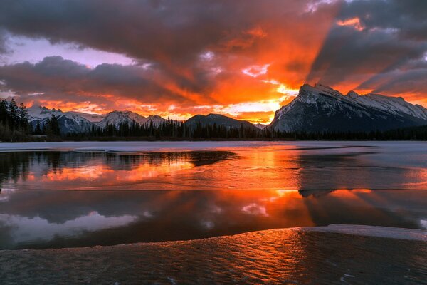 Winter dawn spreads like a fire over the lake