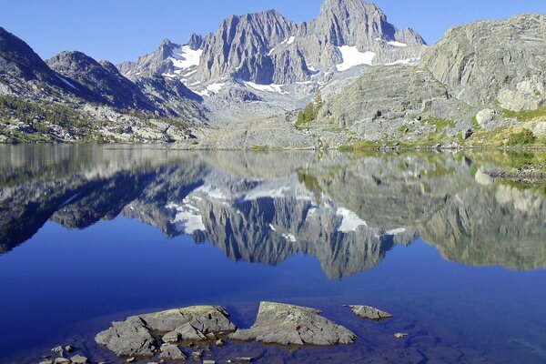 Montañas nevadas se reflejan en el lago