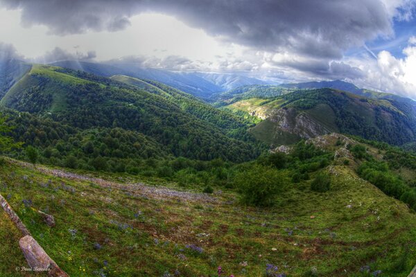 Луг с холмами над которыми плывут облака