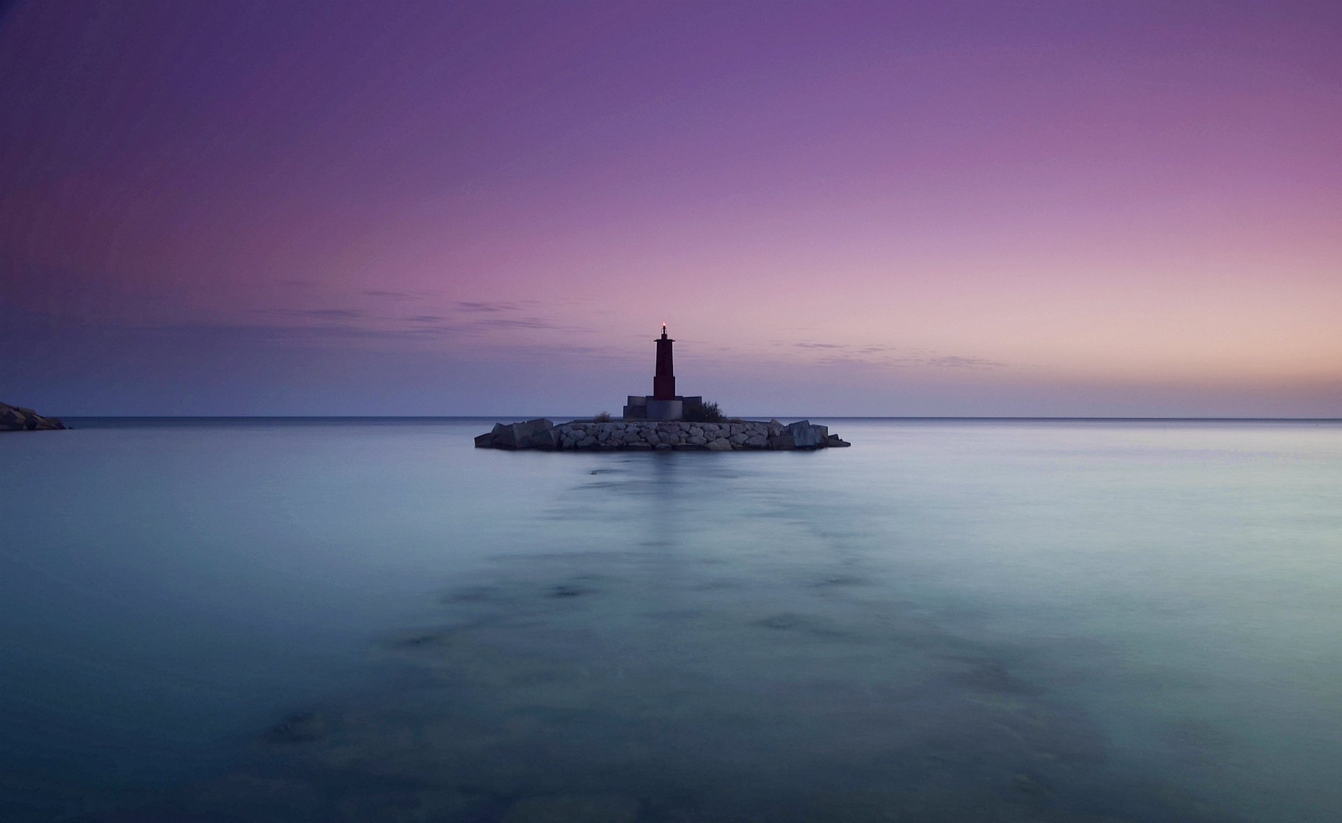 mare oceano calma faro sera lilla cielo