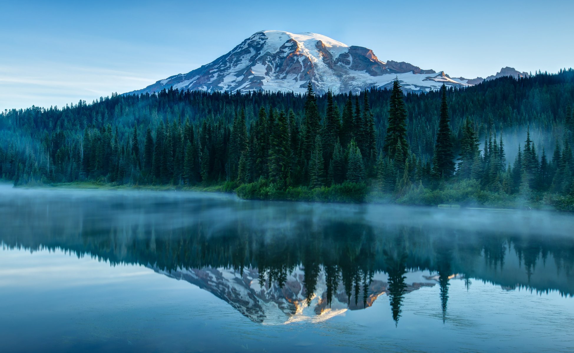 stati uniti stato di washington parco nazionale stratovulcano montagna rainier foresta alberi nebbia blu cielo natura fiume acqua superficie liscia riflessione