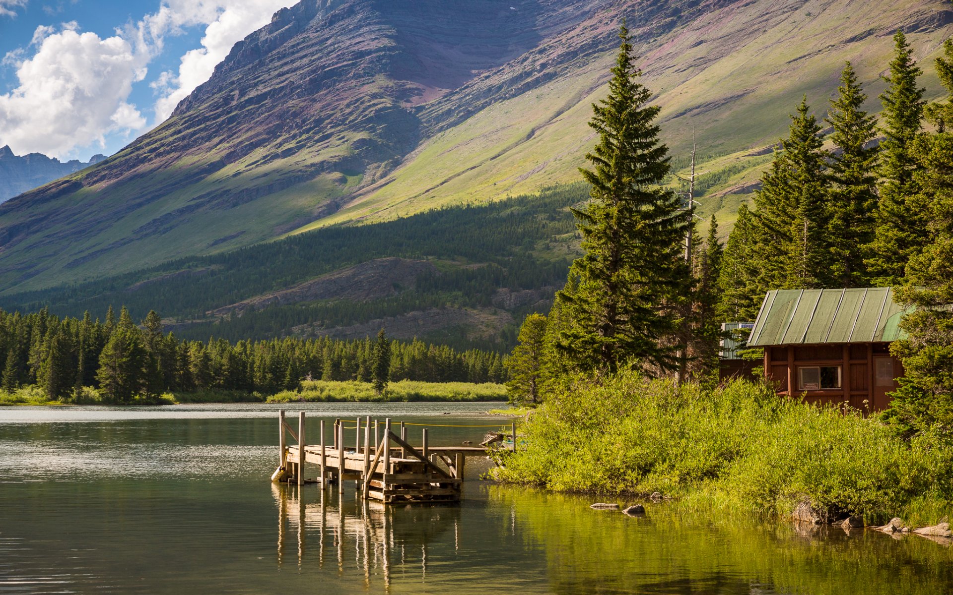 caminata al lago parque nacional glacier montana estados unidos cielo montañas lago árboles casa puente