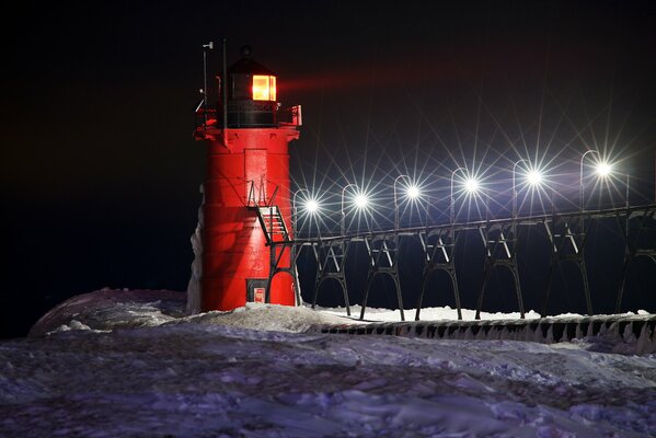 A night lighthouse among the snow in winter