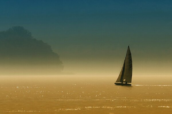 Barca a vela solitaria sulla superficie di un lago calmo