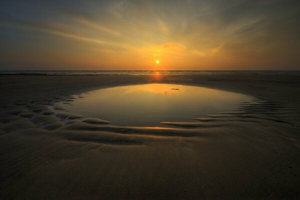 Crepúsculo sobre la playa dorada del mar