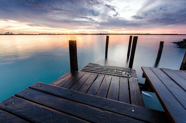 Wooden pier on the river at sunset