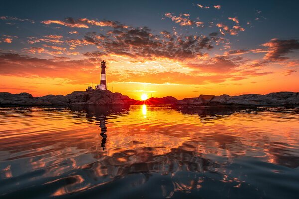 Orange Sonnenuntergang über dem Meer und Leuchtturm